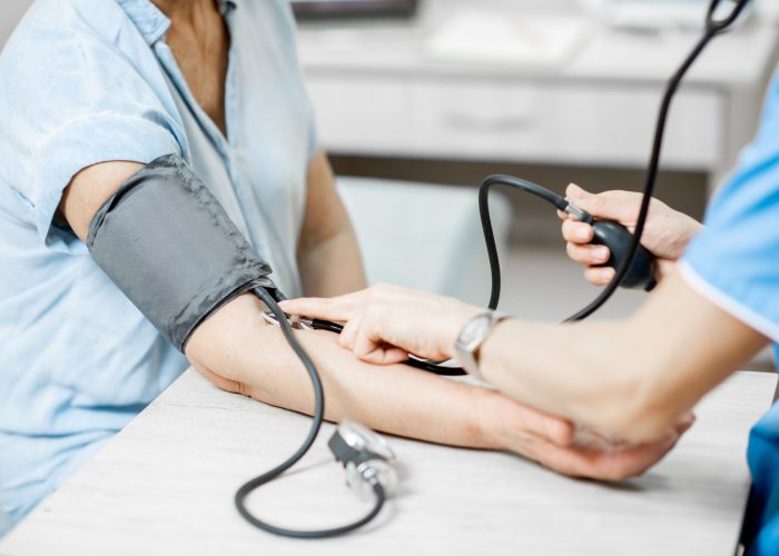 Nurse measuring blood pressure of a senior patient