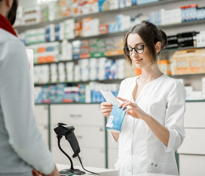 Pharmacist selling medications in the pharmacy store