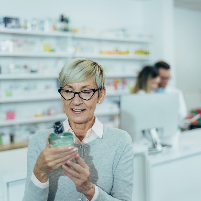 Smiling senior female patient in a pharmacy